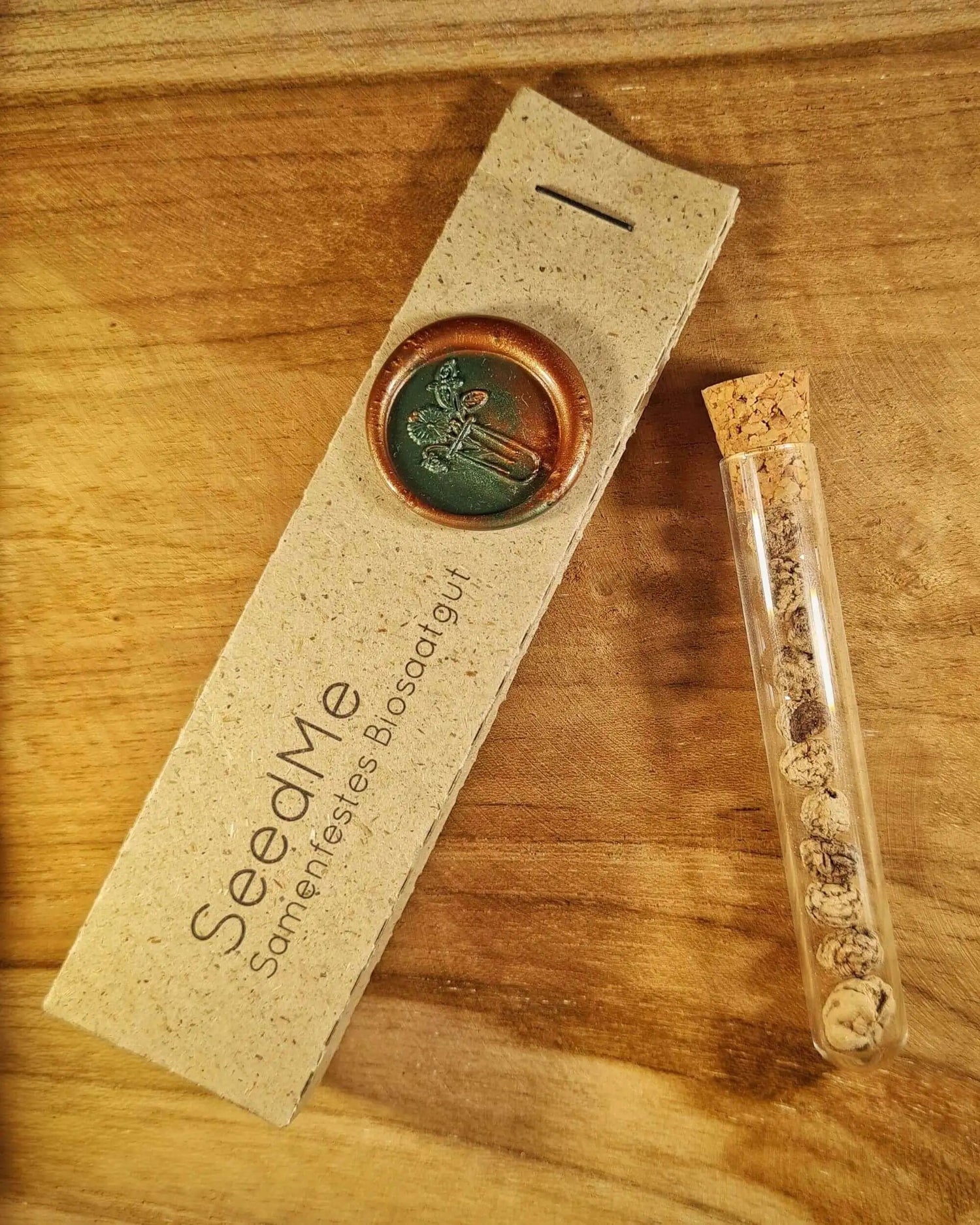 Samen für Kapuzinerkresse im Reagenzglas und daneben eine Graspapierverpackung von SeedMe