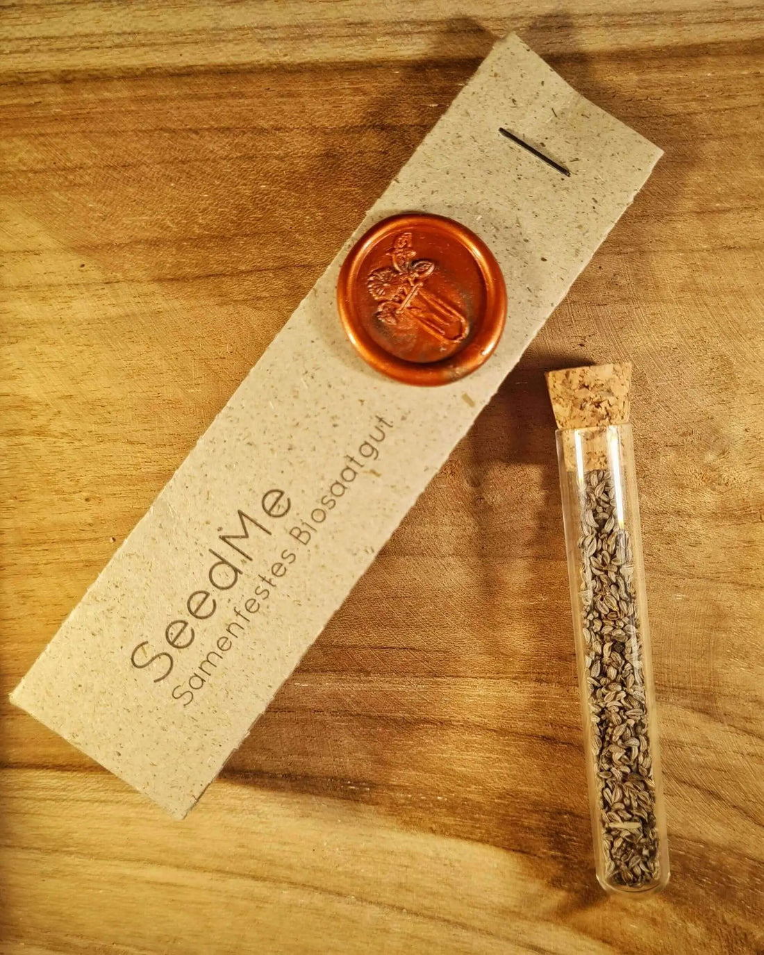Saatgut für Petersilie &quot;Mooskrause&quot; in einem Reagenzglas und daneben eine Graspapierverpackung von SeedMe mit buntem Reagenzglas